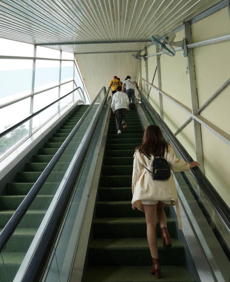 woman-is-going-up-escalator-with-black-backpack